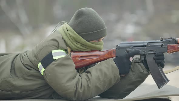 Side View of Confident Military Woman Aiming Lying on Tactical Karemat Outdoors