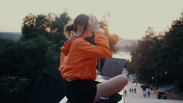 A Beautiful Young Woman Freelancer Who Arranges Her Hair By Ear After Which She Continues to Type on