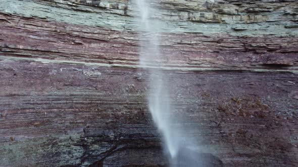 drone footage of a waterfall from a rocky cliff