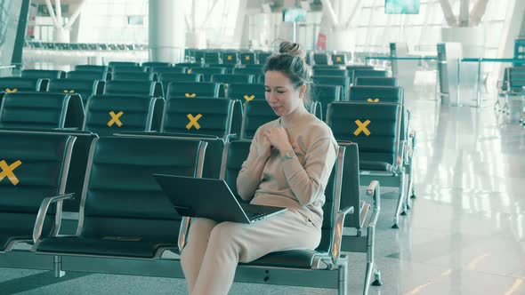 A Woman with a Laptop in the Empty Departure Lounge