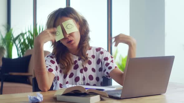 Sleeping Female Office Worker Covering Her Eyes with Sticky Notes