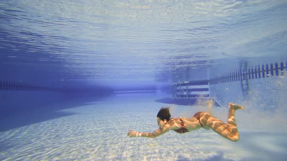 the Young Girl Dive in Swimming Pool, Underwater Slow Motion