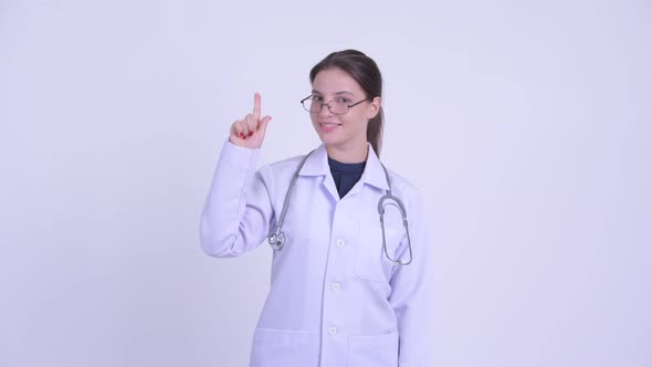 Happy Young Beautiful Woman Doctor Pointing Up