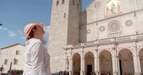 Traveler woman in hat sightseeing antique cathedral in Italy