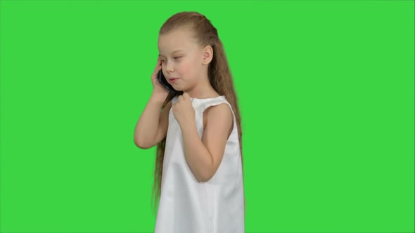 Cute Little Girl Talking on the Cell Phone on a Green Screen, Chroma Key