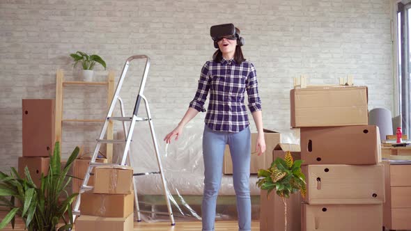 Young Woman in Virtual Reality Glasses Next To Boxes