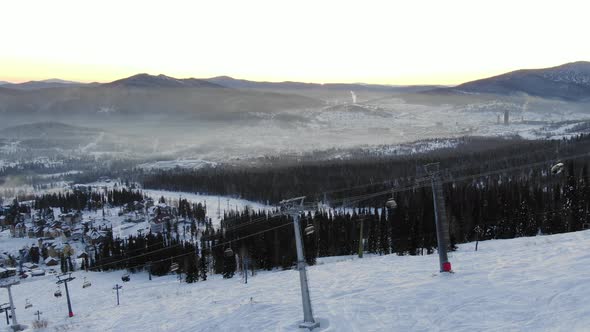 Long Chairlift Moves Over White Snow on Ski Resort Territory