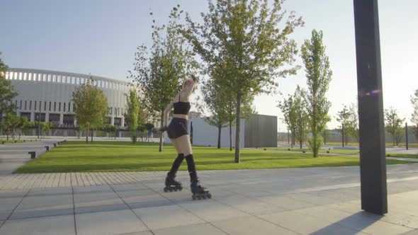 Beautiful Young Woman On Rollerblading In Park At Sunrise