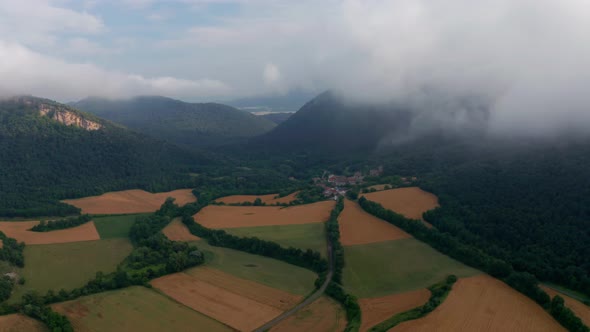 Agricultural fields near mountains under blue cloudy sky