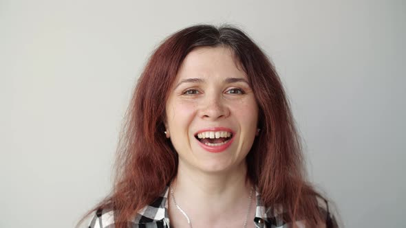 Young Happy Woman Looks in the Mirror and Plucks a Grey Hair From Her Head. Concept Photo of Young