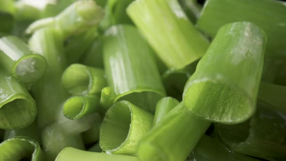 Green Onion Stalks Cut Into Pieces on a Wooden Board