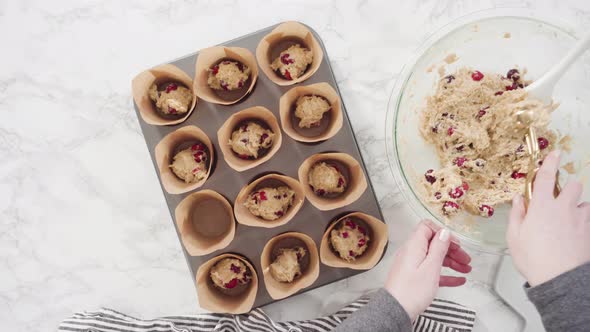 Time lapse. Flat lay. Step by step. Scooping dough into tulip muffin liners with mixture scoop to ba