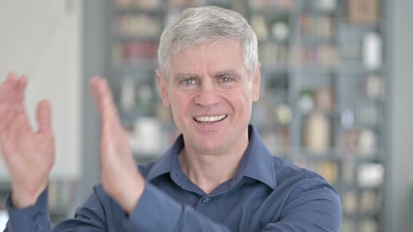 Portrait of Cheerful Middle Aged Man Clapping with Hands