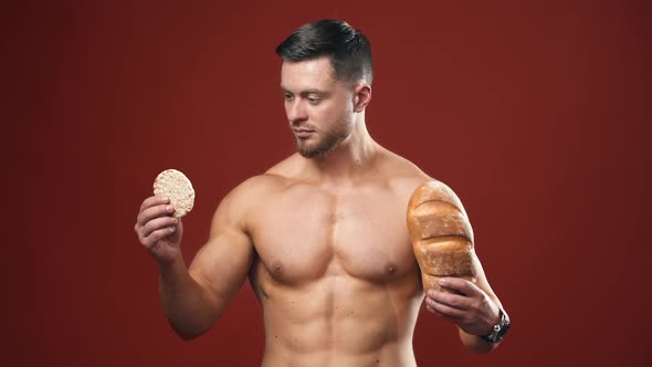 Healthy food choices. Naked sportsman choosing between healthy and unhealthy bread