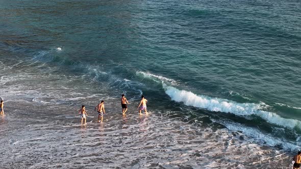 Friends play on the sea waves of the beach aerial view 4 K