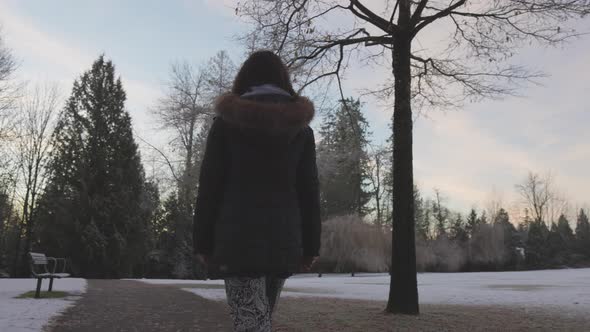 Girl Walking in a Park During Foggy Winter Sunrise