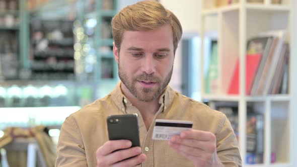 Portrait of Online Payment Success of Young Man on Phone 