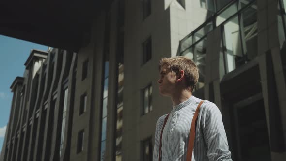 Man Looking to Camera While Standing Outdoors Business Building on the Background