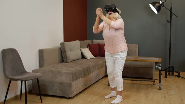 Happy Senior Woman in Virtual Reality Headset Glasses, Trying To Touch Something, Watching 3D Video