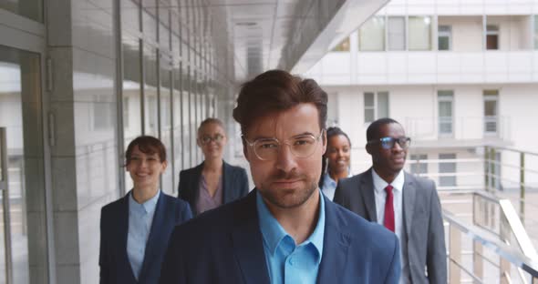 Successful Team of Diverse Business People Confidently Striding Along Office Building