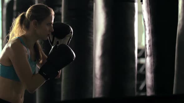 Woman does Muay Thai kickboxing training at the gym.