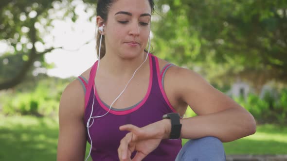 Woman looking at her watch in a park