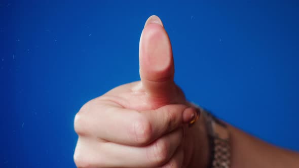 Female Human Hand Making Thumb Fingerprint on Blue Background