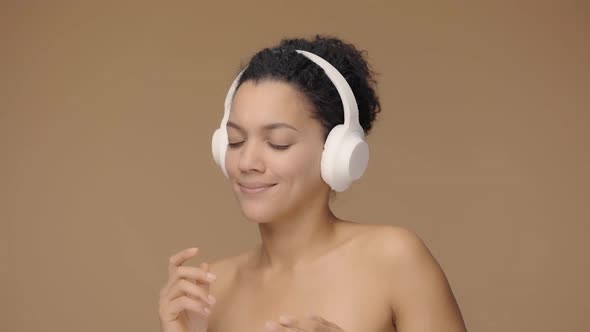 Beauty Portrait of Young African American Woman Dancing and Enjoying Music in Big White Headphones