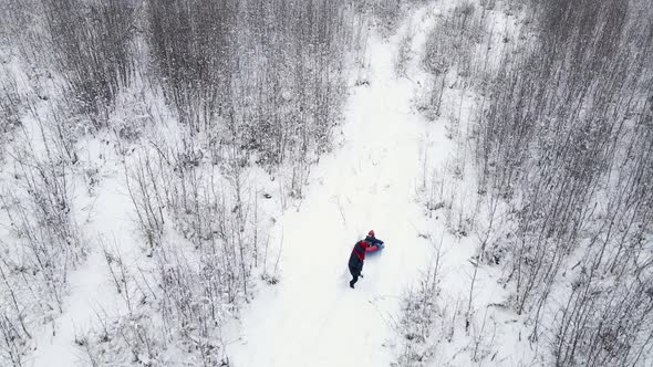 Mom and Child Ride a Tubing in Winter