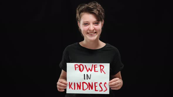 Positive Laughing Woman Posing with Power in Kindness Poster at Black Background