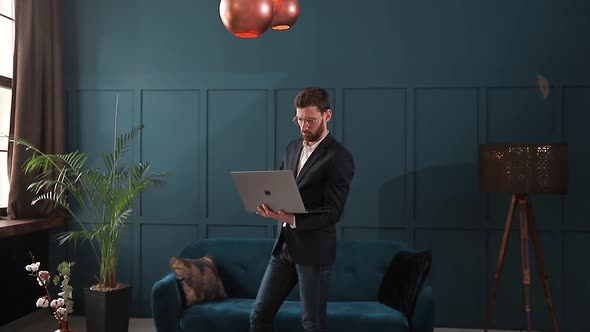 Portrait of an Elegant Businessman with Laptop at the Luxury Blue Office Interior.
