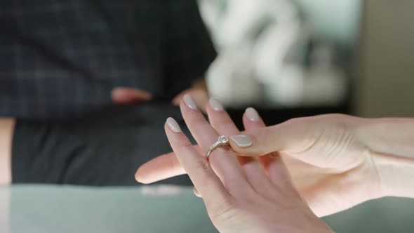 Hands of Woman Trying on Silver Ring