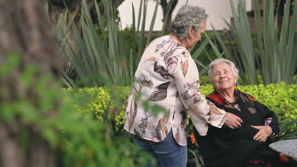 Senior woman kissing sister on head