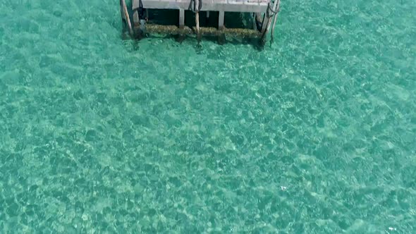 revealing aerial of gazebo on a dock out in the ocean on a tropical island, Koh Kood, Thailand. CROP