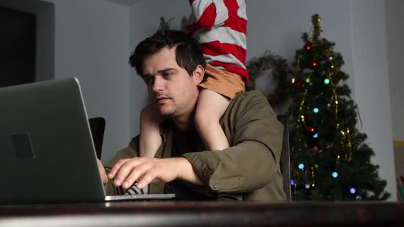 Father with son work with laptop computer at home