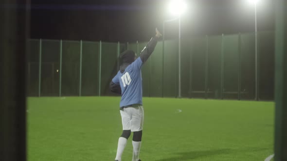 Man Greeting Invisible Audience on Soccer Field