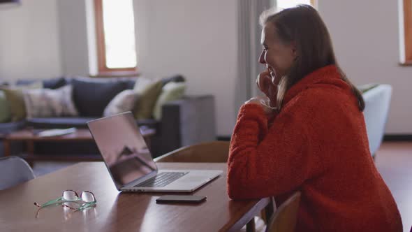 Woman having a video chat on her laptop at home