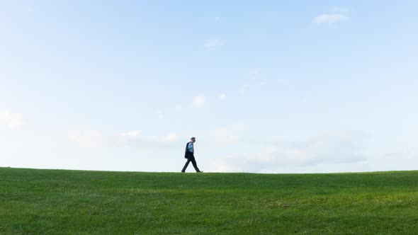 Businessman walking on a hill