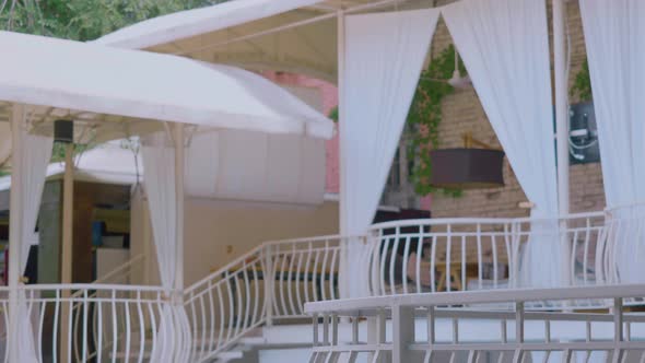 Afro Woman Goes Walks on Balcony in Glasses Drinking Cold Cocktail, Curly-haired Girl in Red