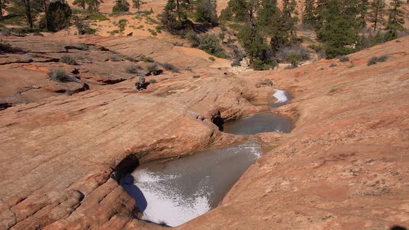 Hiking past frozen pools of water in the desert sandstone