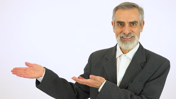 An Elderly Man Presents Something To the Camera with a Smile - White Screen Studio