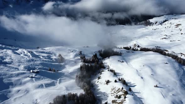 Slow pan up showing off the winter scenery in the Dolomites, while clouds are moving in front of the