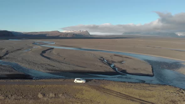 Aerial Shot of a Car Parked Above a Glacial River System.