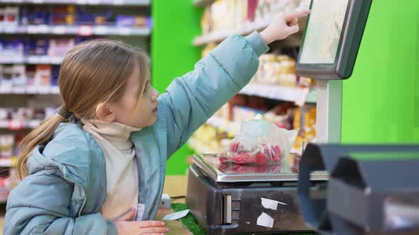 a Little Girl Weighs Candy on Scales in the Store