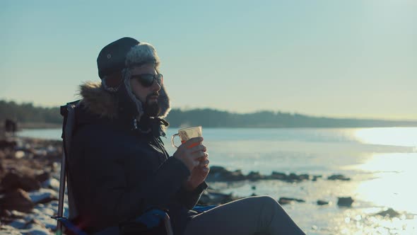 Man Pouring Hot Tea Into Cup. Hot Coffee From Thermos. Holiday Vacation Trip And Relaxing Moment.