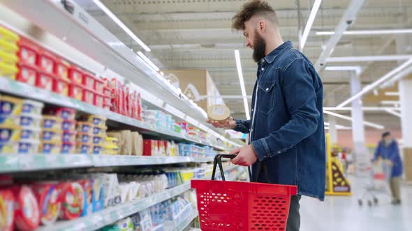 Buying Cheese in Supermarket Man is Checking Shelf Life Reading Labels