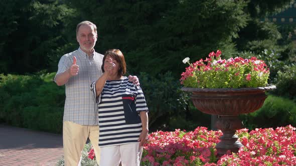 Portrait of Senior Couple Showing Thumbs Up at Park