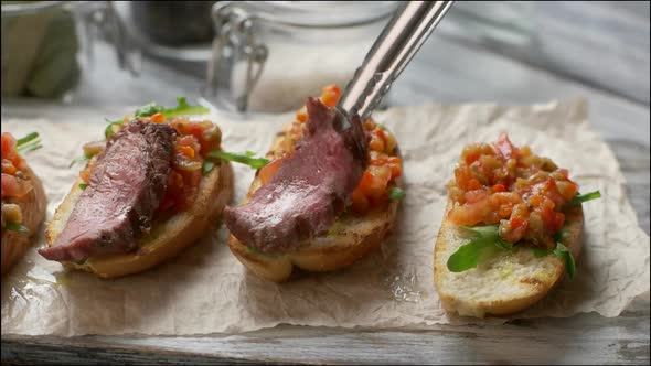 Tongs Put Meat on Vegetables.