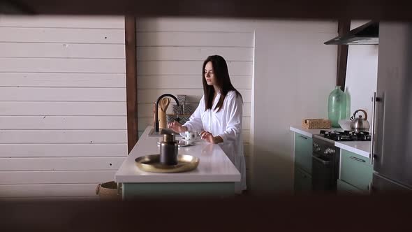 Girl drinking coffee in the kitchen