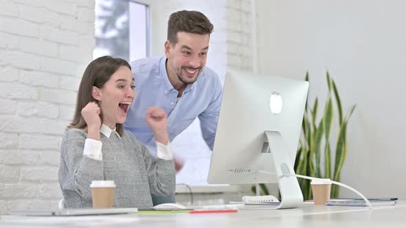 Creative Team Celebrating Success on Desktop By High-Five